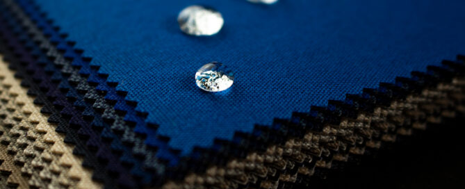 A stack of Sunbrella fabric with three drops of water on top.