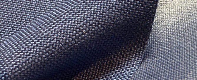 Navy blue textured nylon fabric draped, showcasing its weave and color depth.