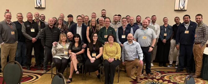 Group photo of an assembly of professionals in a conference setting.
