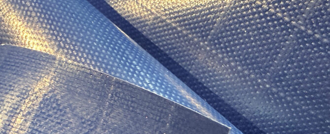 Textured navy blue PVC fabric arranged in overlapping layers.