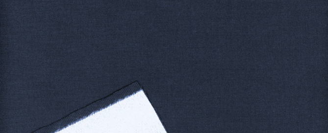 Deep navy fabric with a glossy finish, featuring a folded edge revealing a contrasting white underside.